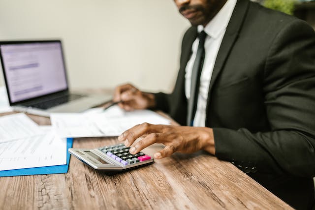 Banker using a calculator while looking over financial statements